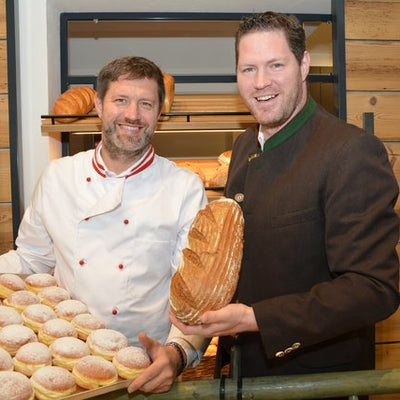 Die Bäcker der Bäckerei Stocklauser mit frischen Krapfen und Brot